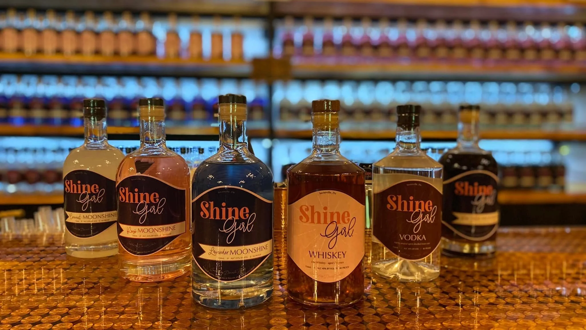Bottles of Shine Girl craft moonshine on a rustic Appalachian table